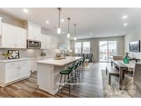 Modern kitchen featuring white cabinetry, stainless steel appliances, and an island with seating at 7126 Hodges Meadow Ln, Charlotte, NC 28213