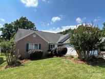 Charming brick home with a well-manicured lawn, lush landscaping, and lovely green shrubbery at 730 Hidden Creek Cir, Salisbury, NC 28147