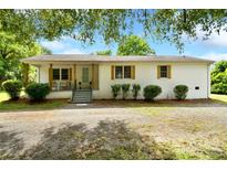 Charming single-story home with a gravel driveway and a welcoming front porch at 80 Sumner Nw Ave, Concord, NC 28027