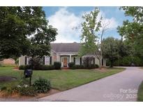 Charming single-story home with a well-manicured lawn, lovely landscaping and a curved driveway at 8829 Gelligum Dr, Charlotte, NC 28277
