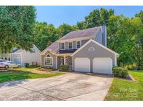 Charming gray two-story home featuring an attached two-car garage and mature landscaping at 8909 Elkins Park Dr, Matthews, NC 28105