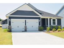 Charming home featuring a two-car garage, beautiful gray siding, and well-manicured lawn, creating great curb appeal at 12209 Riceland Way, Midland, NC 28107