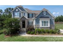 Charming two-story home with stone accents, manicured lawn, and inviting curb appeal at 221 N Centurion Ln, Mount Holly, NC 28120