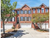 Charming brick townhome featuring a one-car garage, green shutters and a well-manicured front yard at 3114 Luke Crossing Dr, Charlotte, NC 28226
