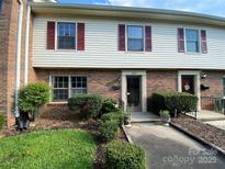 Charming townhome with brick and siding, featuring red shutters and well-maintained landscaping at 4754 Old Lantern Way, Charlotte, NC 28212