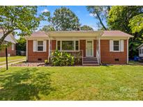 Charming brick home with a cozy front porch, lush lawn, and beautiful curb appeal at 564 Greenway Dr, Statesville, NC 28677