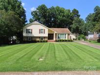 Charming two-story home featuring a well-manicured lawn and mature trees at 5823 Rupert Ln, Charlotte, NC 28215