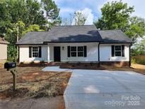 Charming single-story home featuring a well-manicured lawn, a new driveway, and black window shutters at 723 Taylor St, Rock Hill, SC 29730