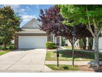 Charming brick front home with a two-car garage, beautiful landscaping, and a well-maintained lawn at 7406 Carolina Jessamine Ct, Indian Land, SC 29707