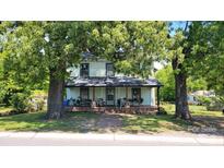 Charming two-story home with a covered front porch and mature trees in the front yard at 164 N Eastway Dr, Troutman, NC 28166