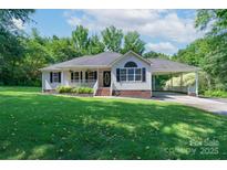 Charming single-story home with a covered porch, attached carport, and a lush green lawn at 1782 Oakdale Rd, Rock Hill, SC 29730