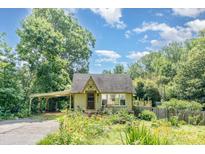 Charming home featuring lush landscaping, a covered carport, and inviting curb appeal on a sunny day at 4124 Oakwood Rd, Charlotte, NC 28269