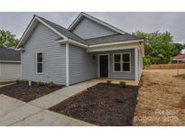 Charming single-story home with light blue siding, walkway, and freshly mulched flowerbeds at 651 S Elm St # 2, Statesville, NC 28677