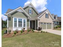 Charming home featuring manicured lawn, two-car garage, and a mix of siding and brick at 10240 Superb Ln, Charlotte, NC 28215