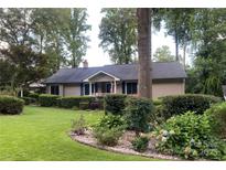 Charming ranch-style home featuring a well-manicured lawn and mature landscaping at 1047 Honeybee Trl, Fort Mill, SC 29715