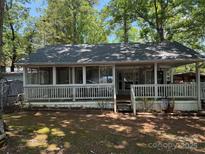 Charming home featuring a screened-in porch with a wooden deck and lush green surroundings at 111/113 Shawnee Trl # D140/141, Mount Gilead, NC 27306
