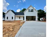 New construction home featuring white vertical siding and dark accents on the roof and window shutters at 1678 Sharon Ln # 12, Lancaster, SC 28720