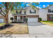 Charming two-story home with brick and siding, a well-manicured lawn, and attached two-car garage at 2316 Savannah Hills Dr, Matthews, NC 28105