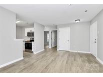 Bright living room featuring sleek flooring and modern white kitchen appliances at 3853 Carl Parmer Dr, Harrisburg, NC 28075