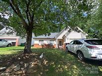 Charming single-Gathering home with a well-maintained lawn, cozy front porch, and ample parking at 7333 Rosehall Dr, Charlotte, NC 28227