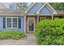 Charming blue home with brick accents and a welcoming front entrance and landscaping at 9136 Four Mile Creek Rd, Charlotte, NC 28277