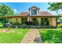 Charming home featuring a covered porch, brick pathway, and welcoming curb appeal at 106 Guffey Rd, Cherryville, NC 28021