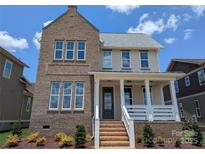 Charming two-story home showcasing a brick facade, covered porch, and professionally landscaped front yard at 113 Macland Ln # 538, Rock Hill, SC 29730