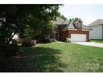 Charming brick two-story home with manicured lawn and attached two-car garage at 12520 Vantage Point Ln, Huntersville, NC 28078