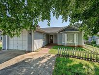 Charming single-story home featuring a well-maintained front yard with mature trees and a white picket fence at 2912 Peachwood Ct, Fort Mill, SC 29715
