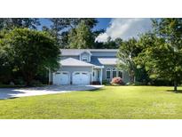 Charming gray home featuring a three-car garage and a well-manicured lawn and driveway at 2949 Glenstone Dr, Rock Hill, SC 29730