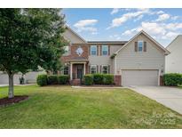 Charming two-story home featuring a brick and siding facade, manicured lawn, and attached two-car garage at 7362 Waterwheel Sw St, Concord, NC 28025