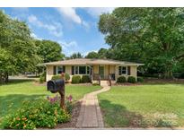 Charming one-story home with a well-maintained front yard, brick walkway, and inviting curb appeal at 810 Lakeview Dr, Pineville, NC 28134