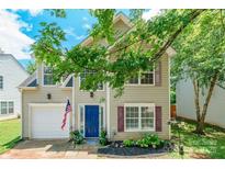 Charming two-story home featuring a blue front door, attached garage, and well-maintained landscaping at 1274 Winding Path Rd, Clover, SC 29710