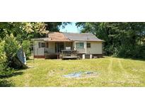 Backyard features a large grassy area, mature trees, and a small porch at 202 N Dilling St, Kings Mountain, NC 28086