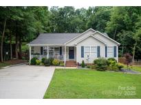 Charming single-Gathering home with light siding, blue shutters, beautiful front yard, and covered porch at 317 Sugar Creek Xing, Fort Mill, SC 29715