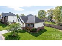 Beautiful home with lush green lawn, and a patio, surrounded by trees, offering privacy and curb appeal at 3837 1St Street Nw Ln, Hickory, NC 28601
