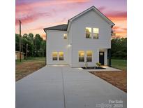Charming two-story home with white siding, a large driveway, and a manicured lawn at 405 E Broad St, Salisbury, NC 28144