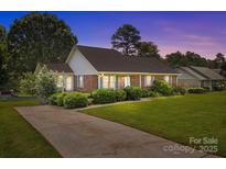 Charming brick home with a well-manicured lawn, mature landscaping, and a private driveway at 416 Park Ave, Granite Quarry, NC 28072