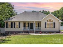 Charming single-story home with a manicured lawn, a welcoming porch, and black shutters at 608 Red Hawk Way, Clover, SC 29710