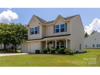 Charming two-story home featuring a well-manicured lawn, attached garage, and inviting front porch at 864 Pointe Andrews Dr, Concord, NC 28025