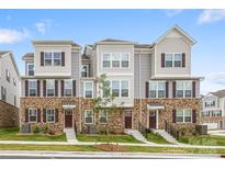 Inviting townhouse featuring brick accents, complementary siding, and well-maintained landscaping at 9921 Oaklawn Nw Blvd, Huntersville, NC 28078
