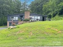Charming two-story home with a brick chimney, deck, garage, and a lush green lawn on a sloped lot at 109 Joe Teague Rd, Hickory, NC 28601