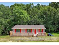Charming single-story home with a spacious wooden deck and red accents at 2611 Dallas Stanley Hwy, Stanley, NC 28164