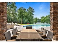 Inviting pool area featuring a large outdoor dining table and lounge seating, perfect for entertaining by the lake at 330 Waters Rd, Salisbury, NC 28146