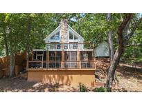 Charming waterfront home with a stone chimney and spacious deck overlooking a wooded area at 113 Harbor Ln # 6, Mount Gilead, NC 27306