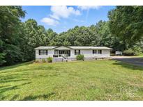 Charming single-story home with a well-manicured lawn, and a welcoming front porch at 222 Laramie Dr, Stanley, NC 28164