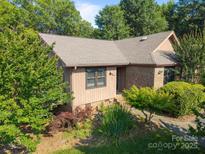 Charming single-story home with a combination of wood and brick, complemented by well-maintained landscaping and mature trees at 2680 Heavens Ct, Fort Mill, SC 29715