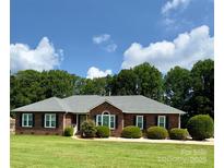 Charming brick home with a well-manicured lawn and dark shutters against a bright blue sky at 2695 Hill Top Dr, Salisbury, NC 28147
