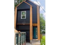 Striking modern exterior with dark siding, natural wood accents, and a bright blue front door at 3049 Reid Ave, Charlotte, NC 28208