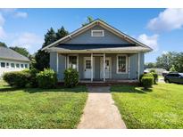 Charming single-story home with a covered front porch, green lawn, and mature landscaping at 404 Community St, Rock Hill, SC 29730